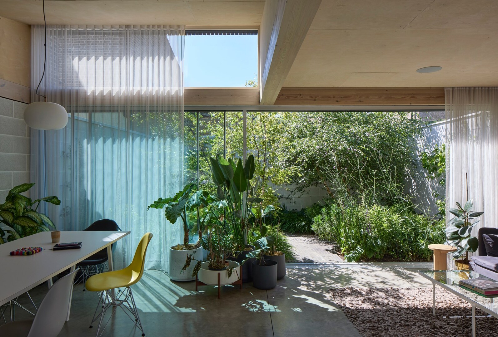 Interior view of a home with large windows overlooking a lush garden.