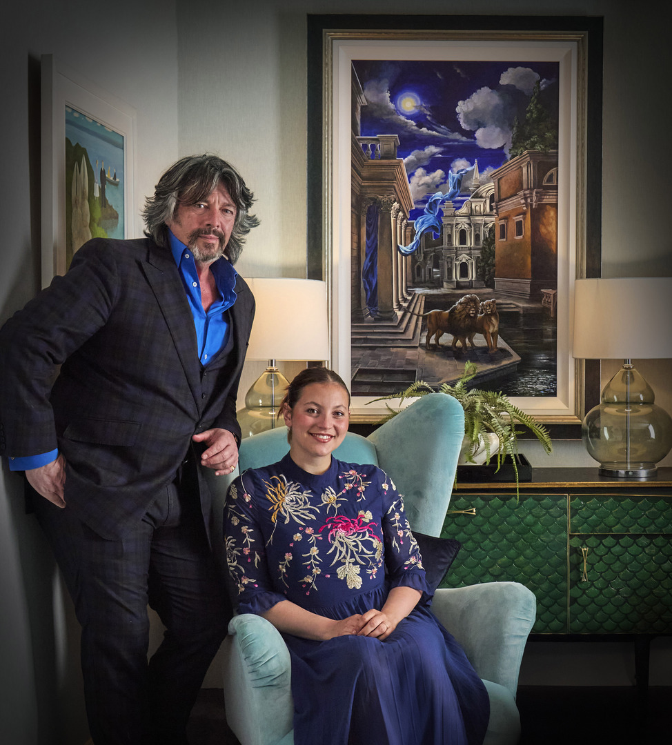 Portrait of Laurence Llewelyn-Bowen and his daughter Hermione in their home, with a painting of lions in Venice in the background.