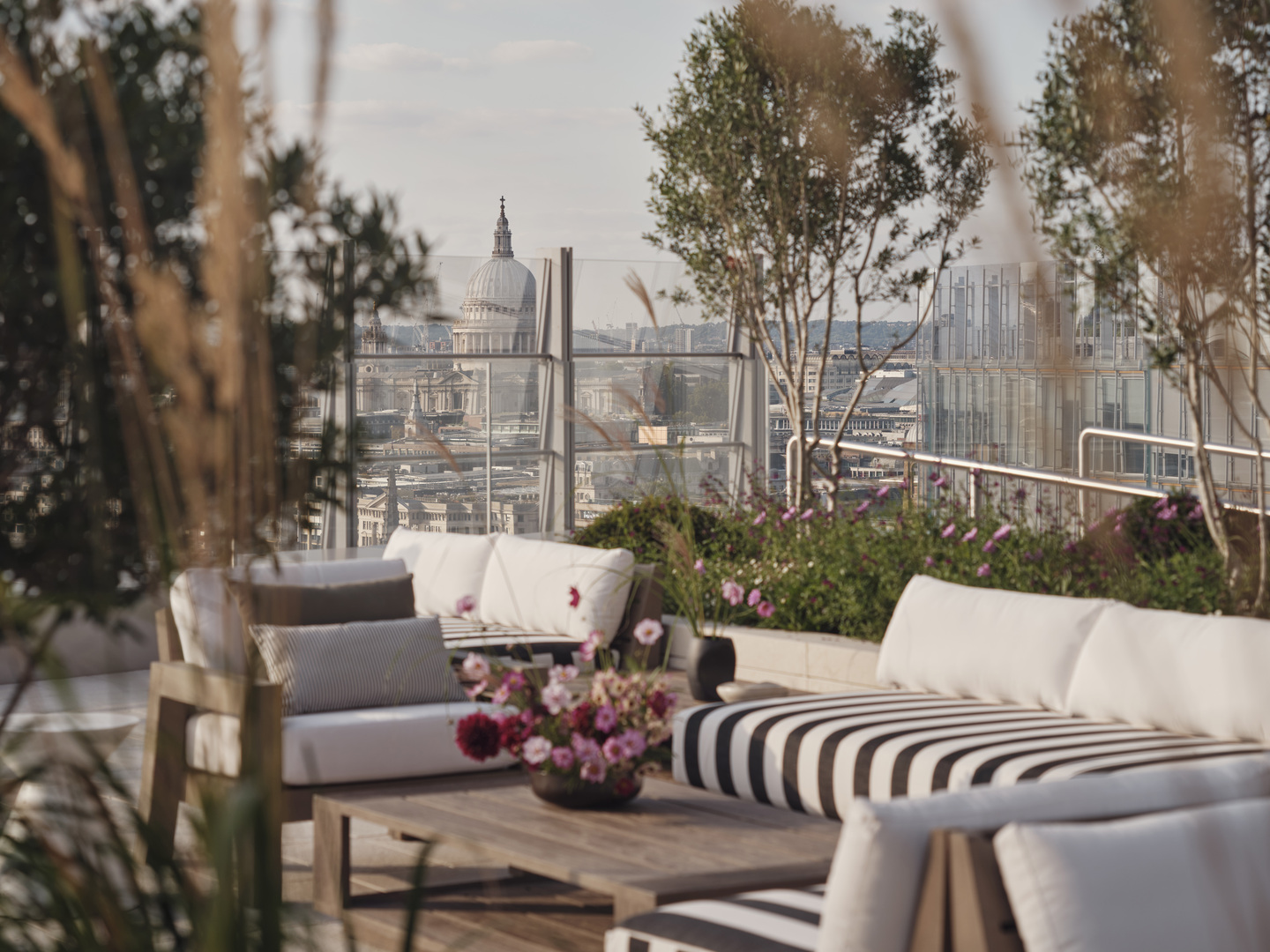 Rooftop lounge furniture overlooking London cityscape with St. Paul's Cathedral visible.