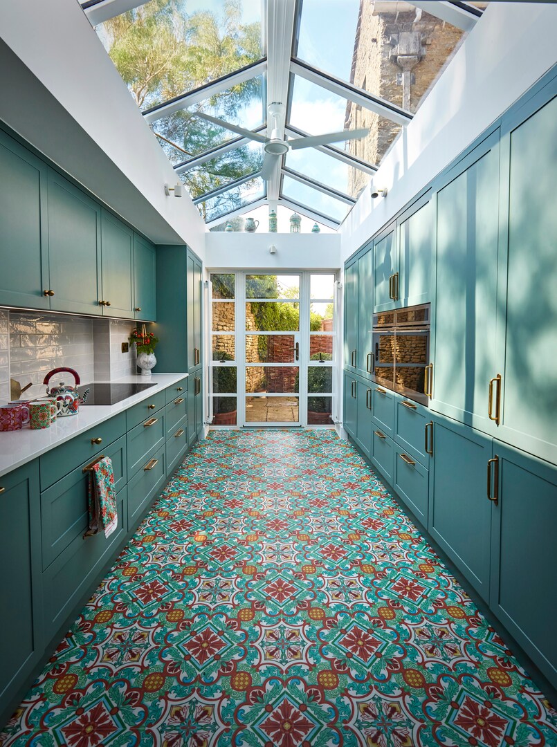 Teal kitchen with patterned floor and glass ceiling.