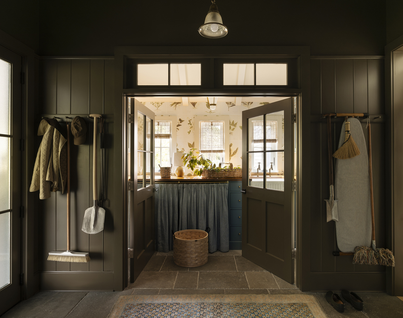Laundry room with dark green walls and a floral wallpapered interior.