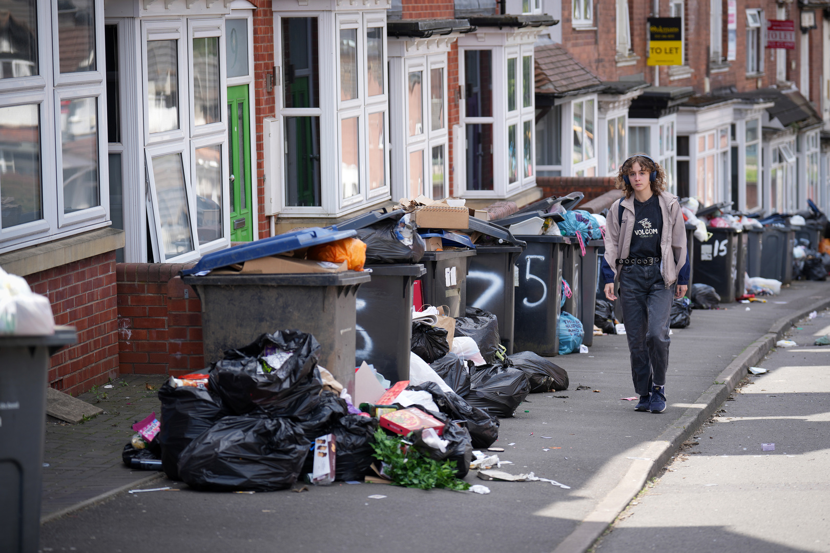Overflowing bins and rubbish on a Birmingham street during a refuse workers' strike.