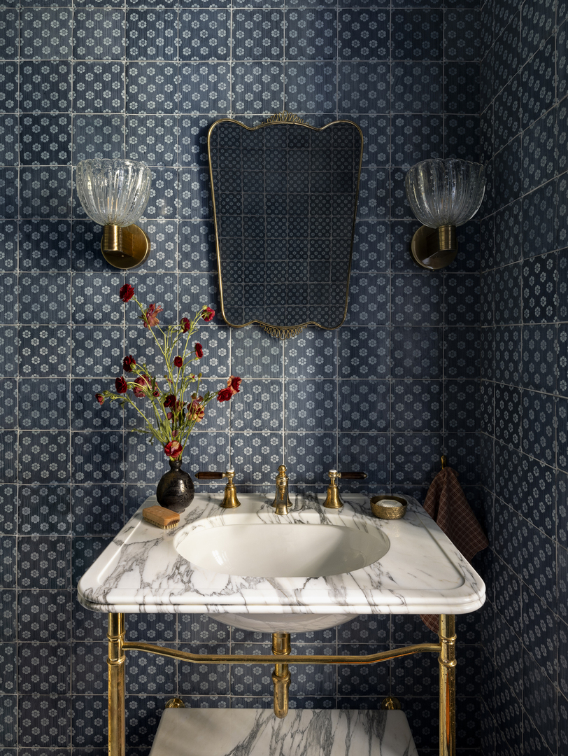 Guest bathroom with marble sink and floral patterned tiles.