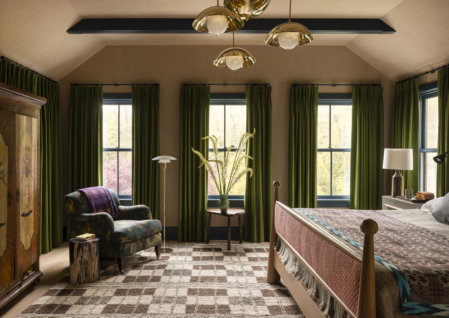 Guest bedroom with green curtains, patterned rug, and custom bed.